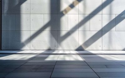 Modern architecture with shadow patterns Sunlight casts geometric shadows on a clean, textured concrete wall and tiled floor