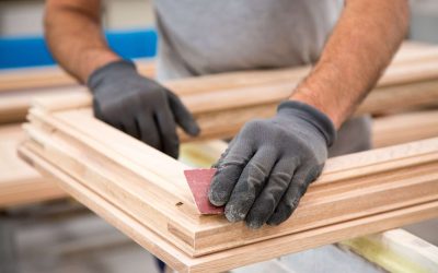 Uomo che scartavetra la cornice di una finestra